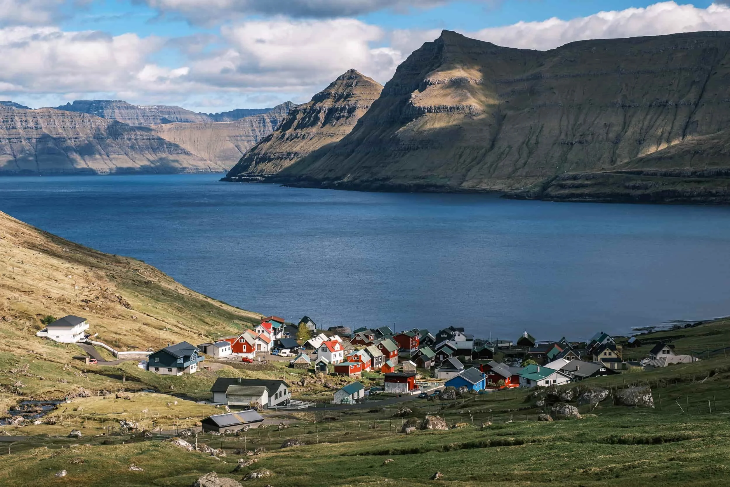 Capturing the power of landscapes: a Faroese village at the foot of cliffs to promote the destination.