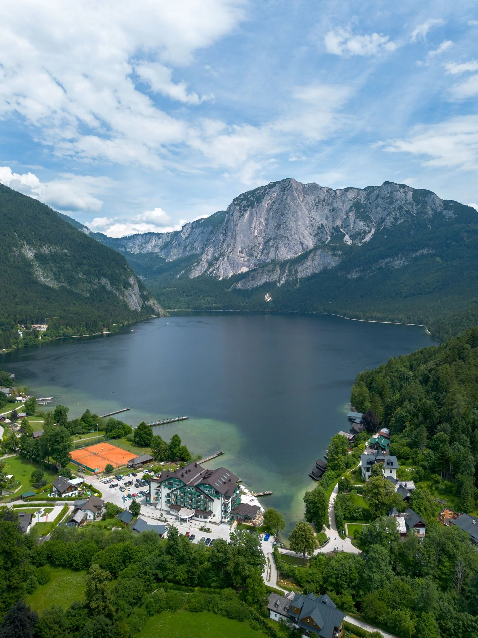 Tyrol - Paysage de lac entouré de montagnes et de forêts avec quelques maisons et un bâtiment principal au bord de l'eau. Reportage outdoor, mise en valeur du territoire et tourisme durable par Guillaume Donsimoni