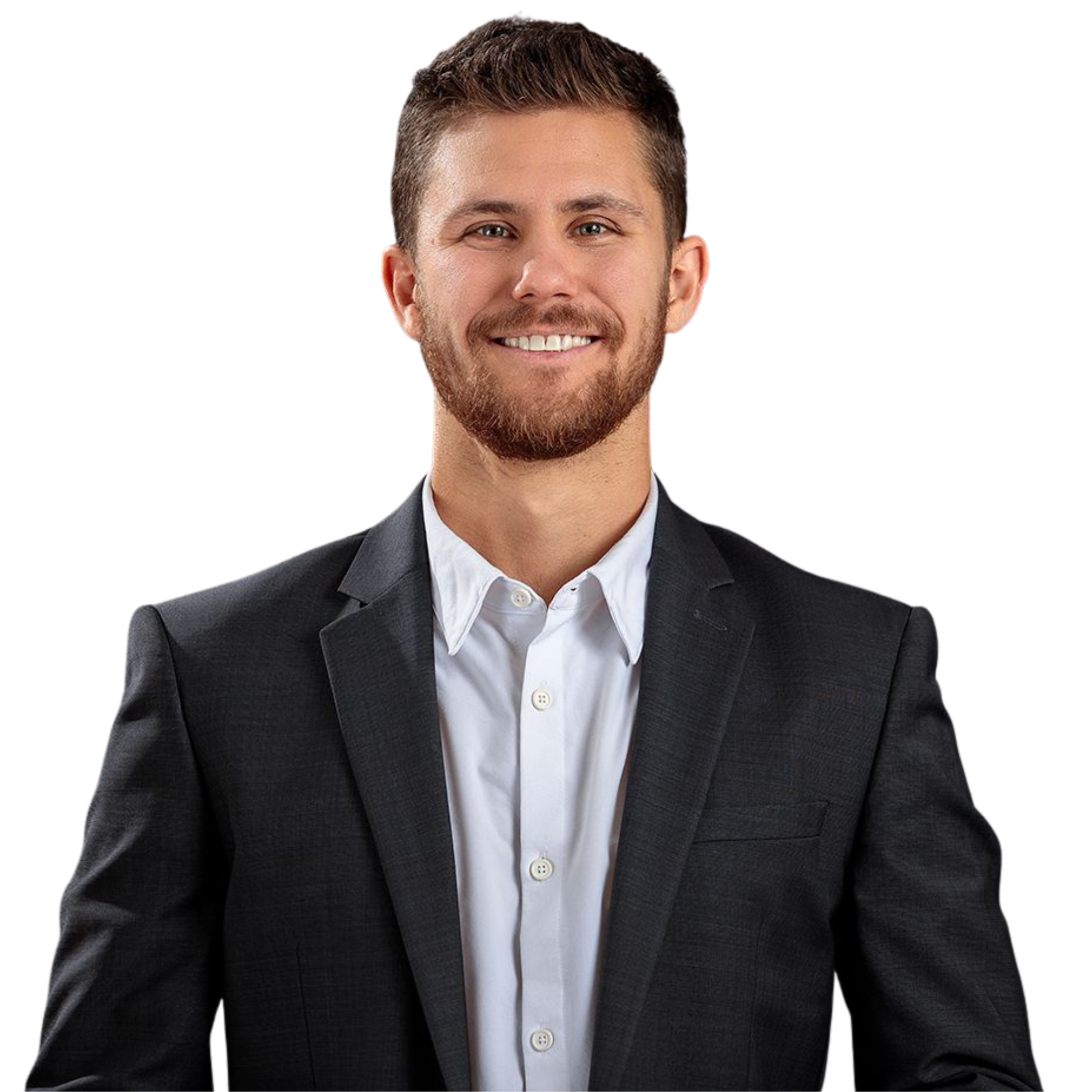 A young man with a beard and short brown hair, dressed in a dark suit jacket and white collared shirt, smiling against a white background.