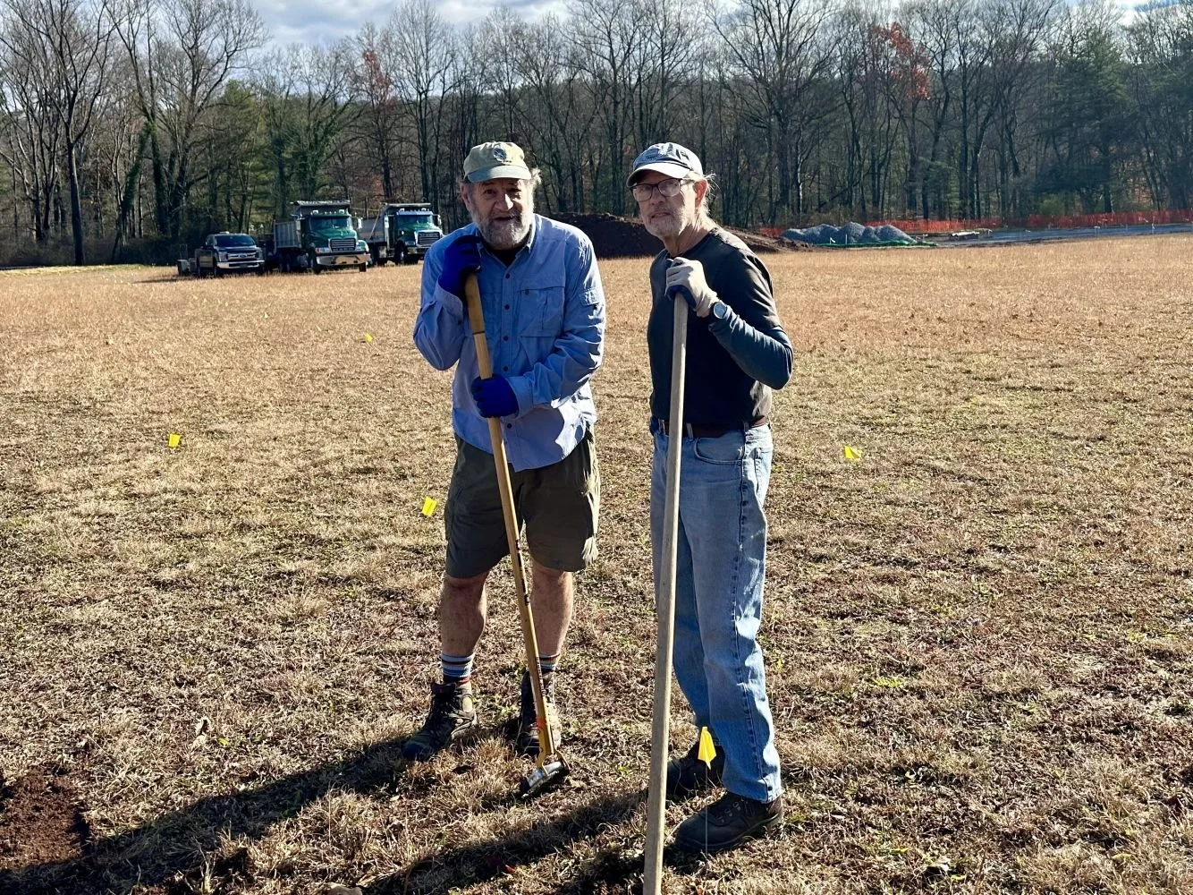 Two men standing in a large open field holding tools at Soldiers Field Mount Gretna PA