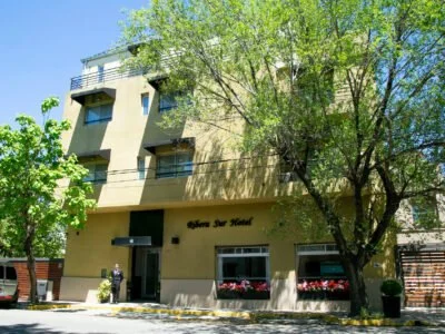 Edificio de hotel con balcones y árboles en la calle