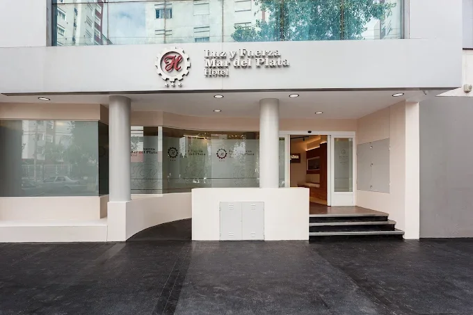 Fachada del hotel: Entrada principal con cartel que dice 'Hacia y Fuerza Mar del Plata Hotel' y ventanas de vidrio en el fondo.