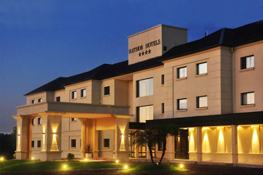 Vista exterior de un hotel llamado Hathon Hotels con iluminación nocturna y cinco estrellas en la señal
