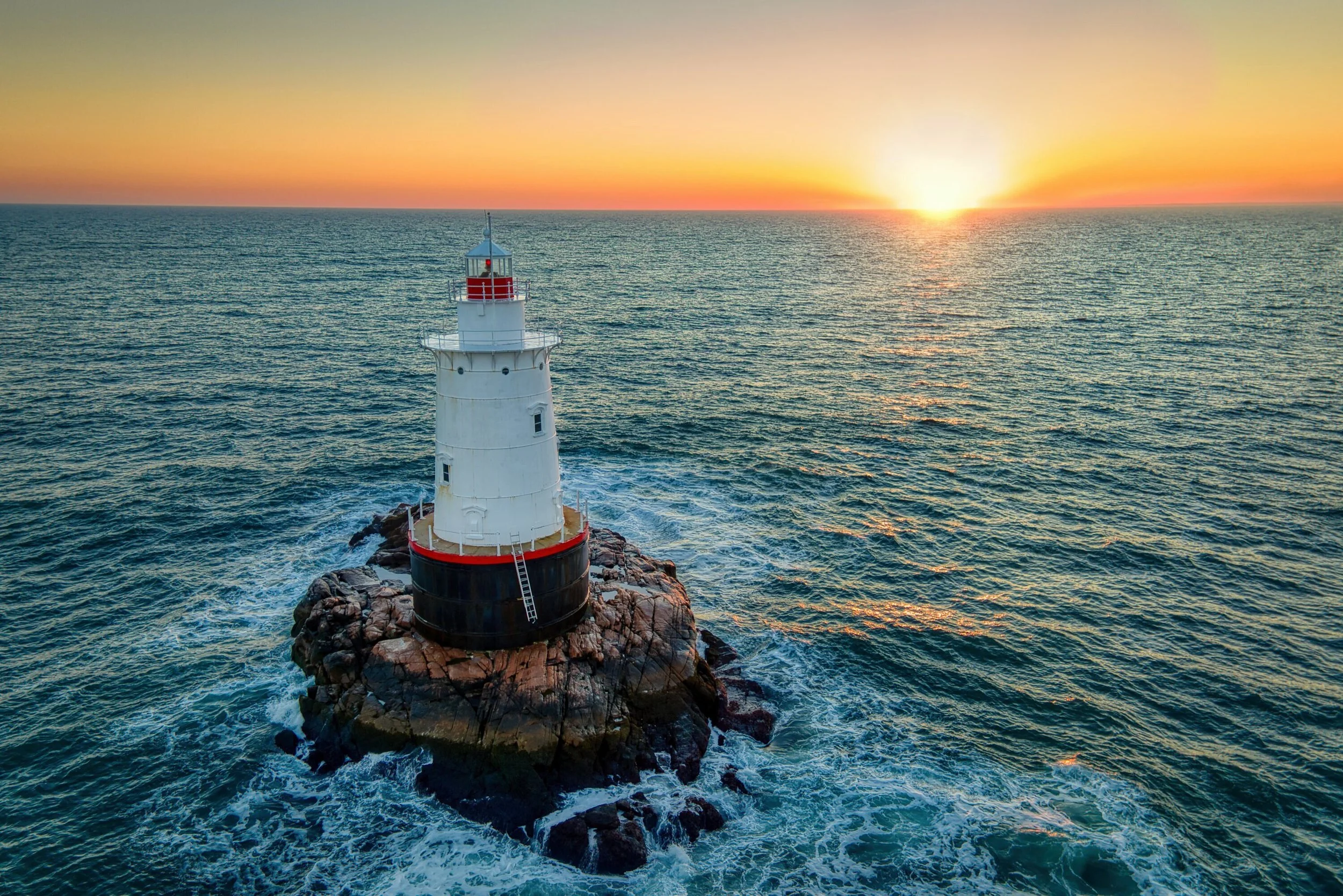 Sakonnet Lighthouse in Little Compton, Rhode Island photographed from above by drone along the coast