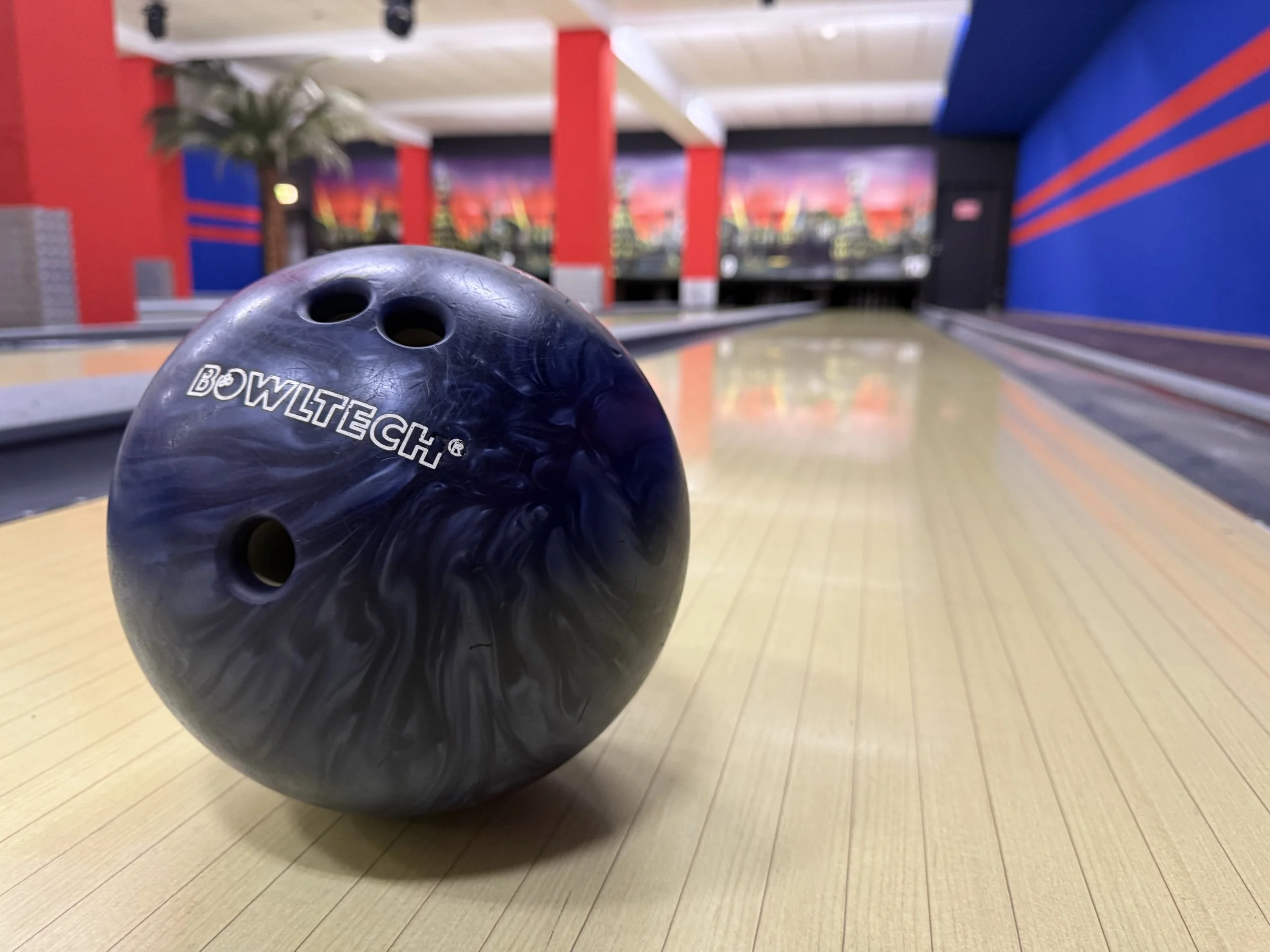 Bulldog-Gummiwalze auf einer Bowlingbahn in einer Halle mit bunten Wänden und Dekorationen.