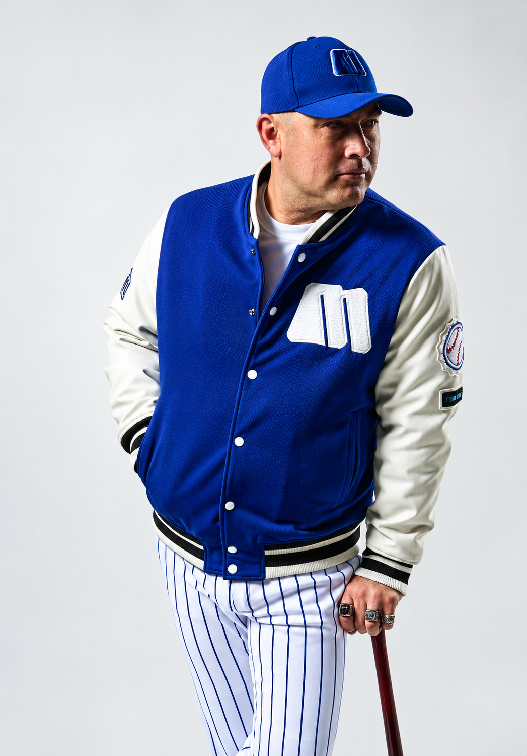 Retrato deportivo con gorra azul y bate.png