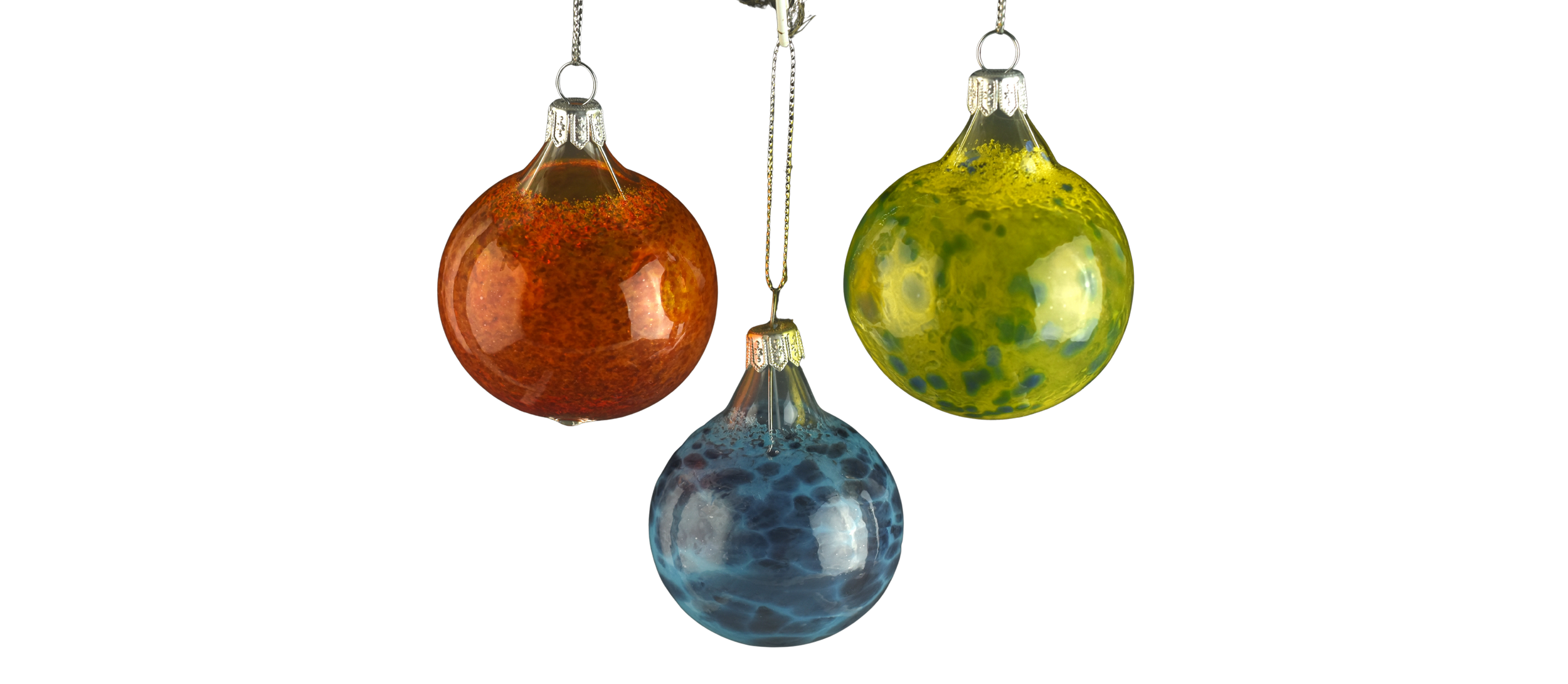 Three colorful glass ornaments hanging against a white background, reflecting their surroundings on their shiny surfaces.