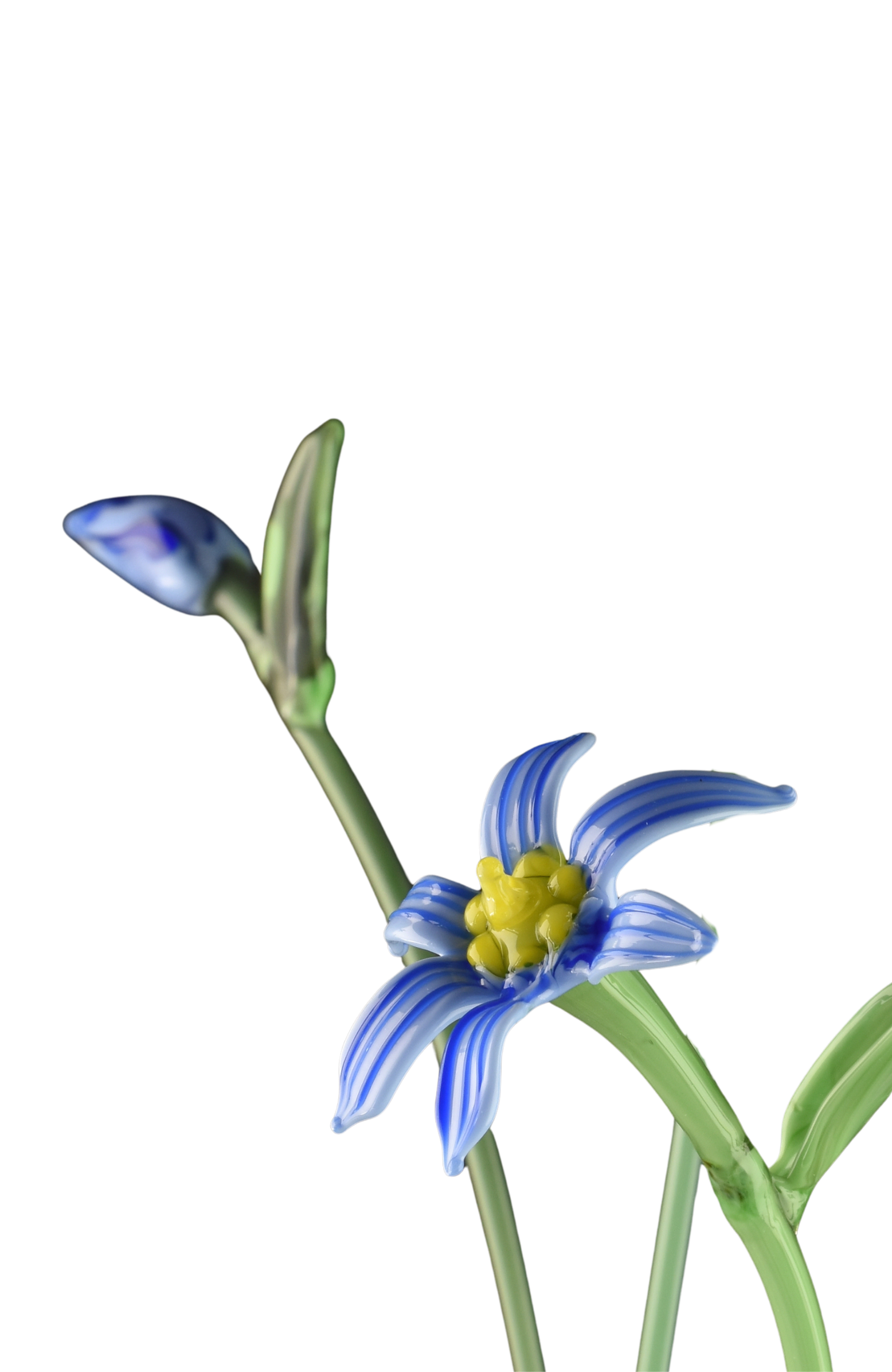 Close-up of a decorative glass flower with blue and white striped petals, yellow center, and a blue and white bud on a green stem.