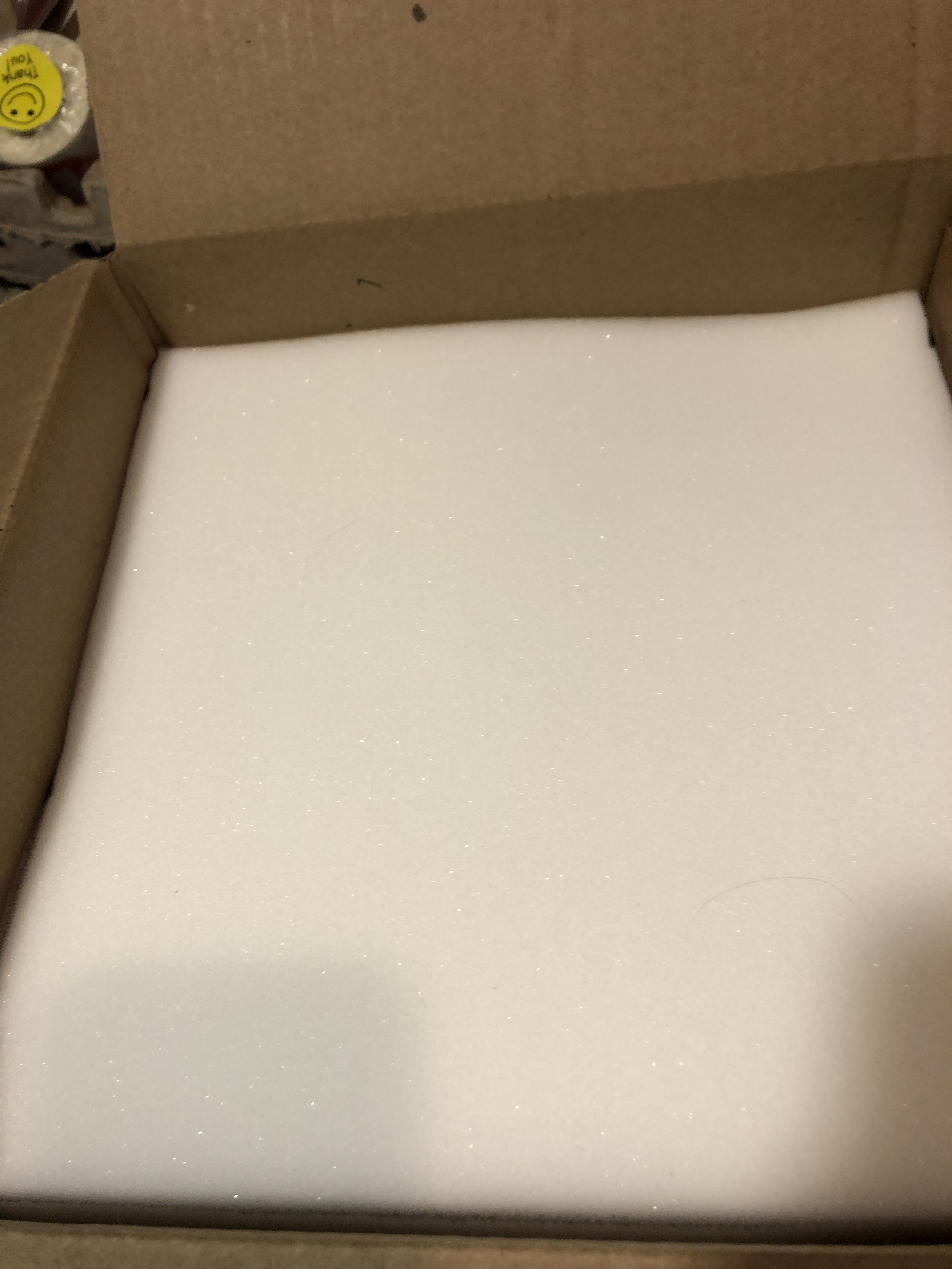 Close-up of a white, foam tray inside a cardboard box.