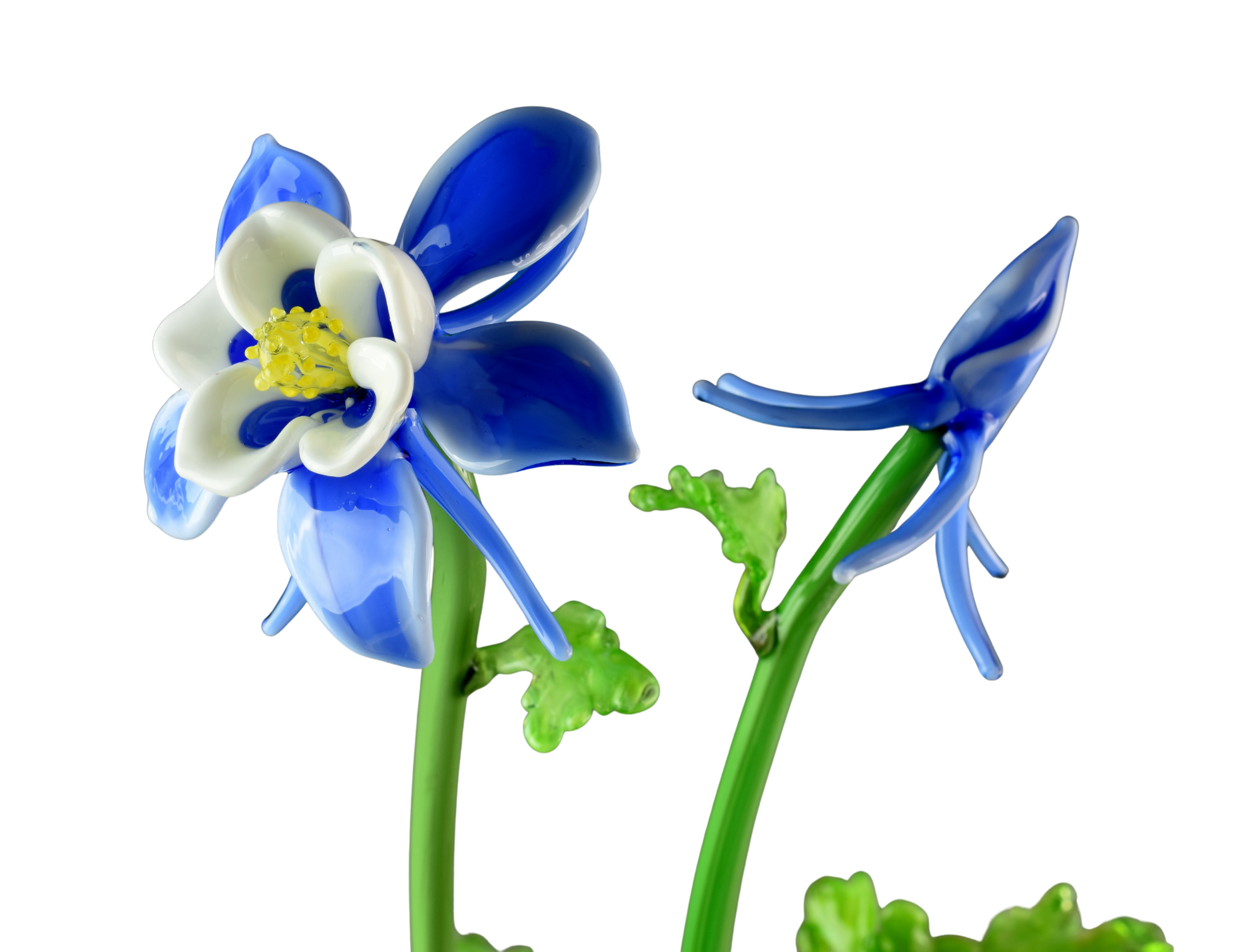Glass sculpture of a flower with white, blue, and yellow parts, on green stems.