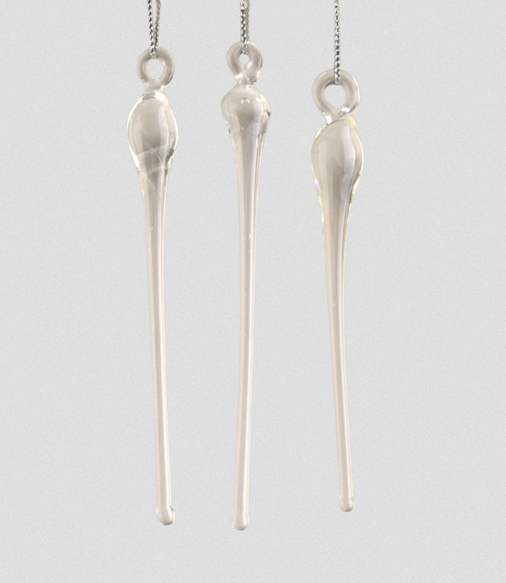 Three glass icicles hanging from silver chains on a light gray background.
