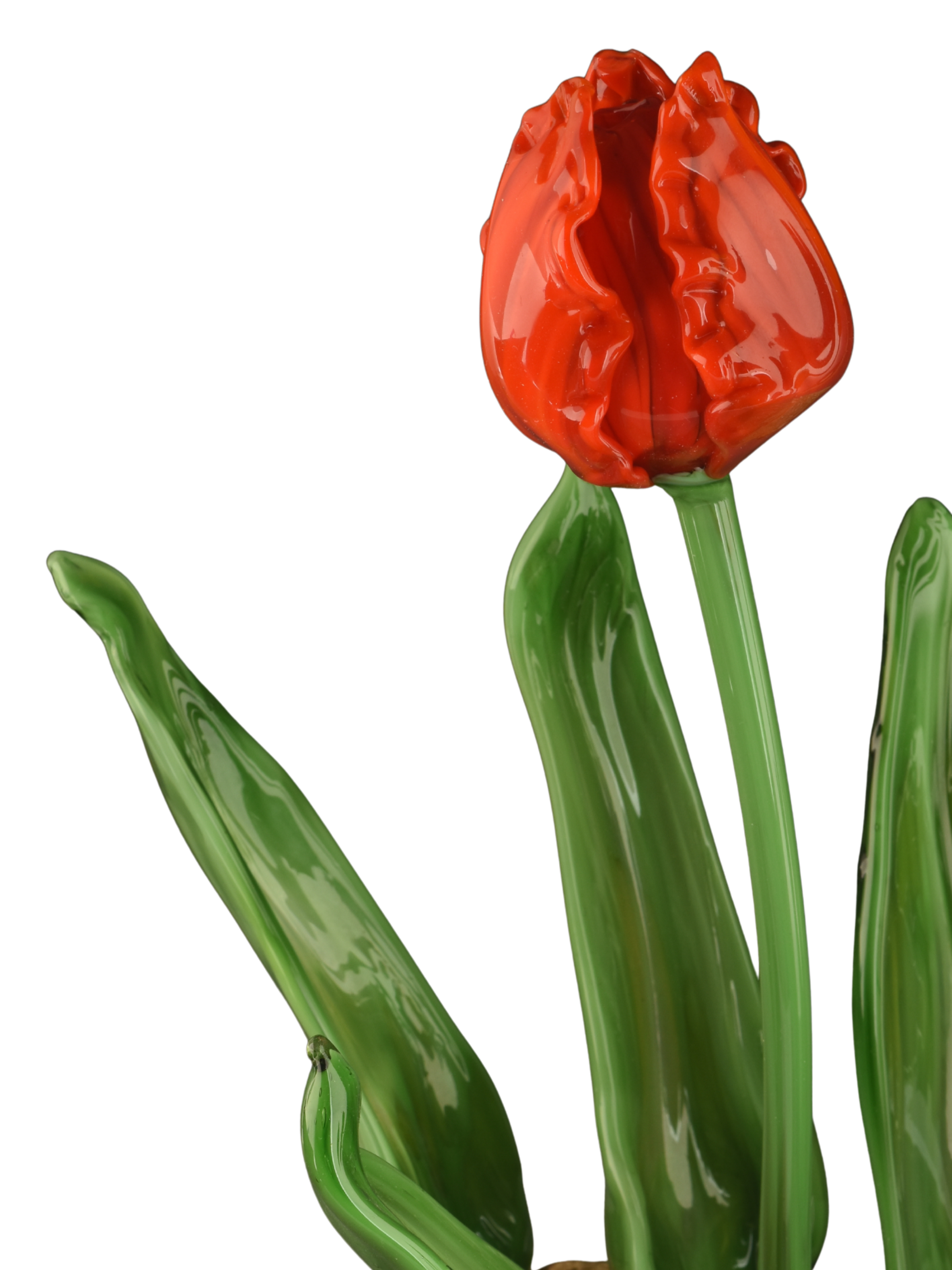 A glass sculpture of a red tulip with green stems and leaves against a black background.
