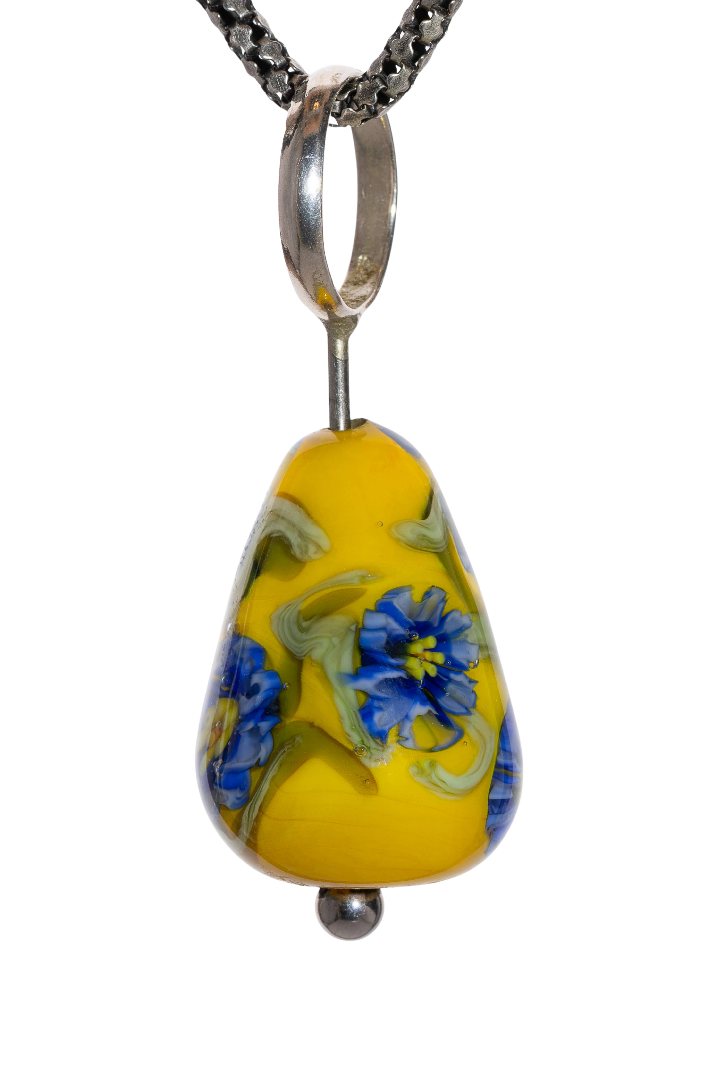 Close-up of glass art pendant with yellow and blue swirls on a chain
