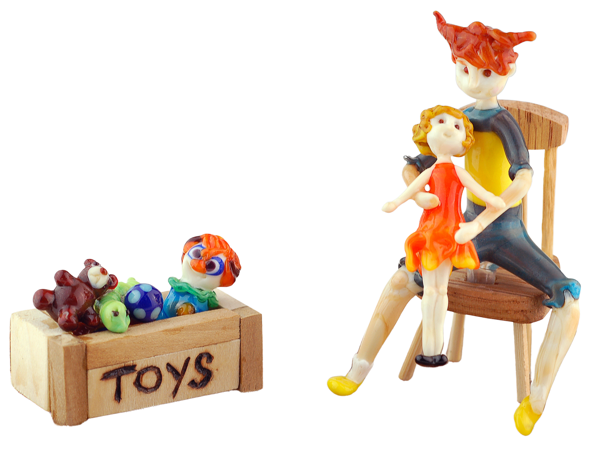 Colorful ceramic toy animals on a wooden box labeled 'TOYS' and a wooden chair. The animals include a brown dog, a green snake, a blue fish, and a multicolored bird. A figurine of a girl and a boy are sitting on the chair."