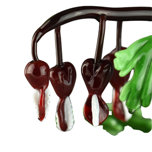 Chocolate-covered cherries hanging from a metal rack, with some stuffed green toy or cloth.