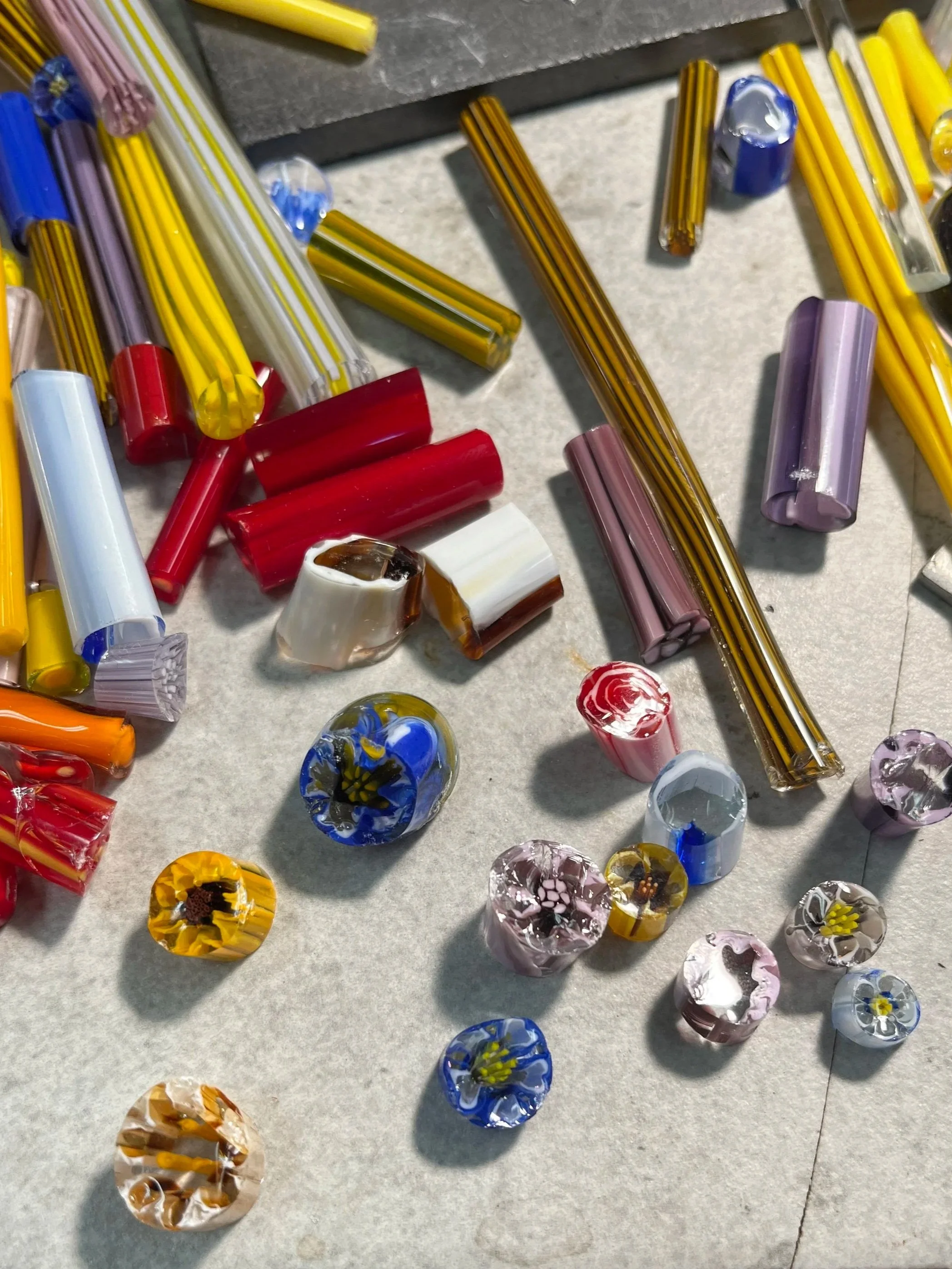 Colorful glass marbles arranged on a surface with some shadows.
