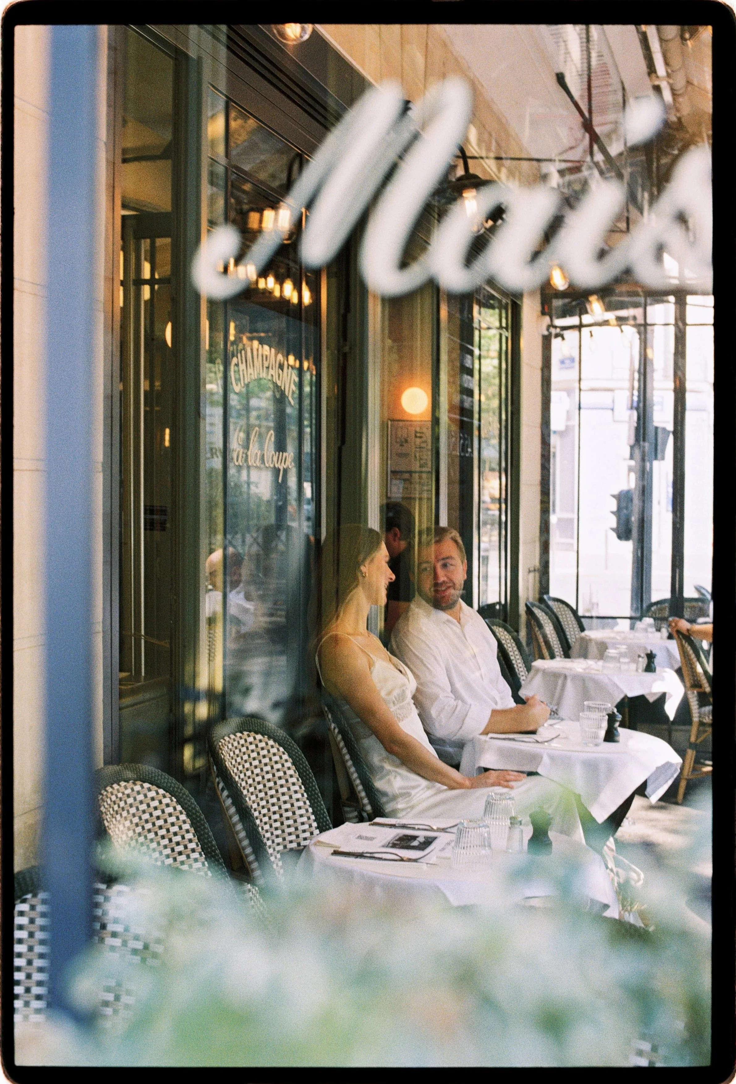Bistro street photography for newly engaged couple in Paris near Eiffel Tower.