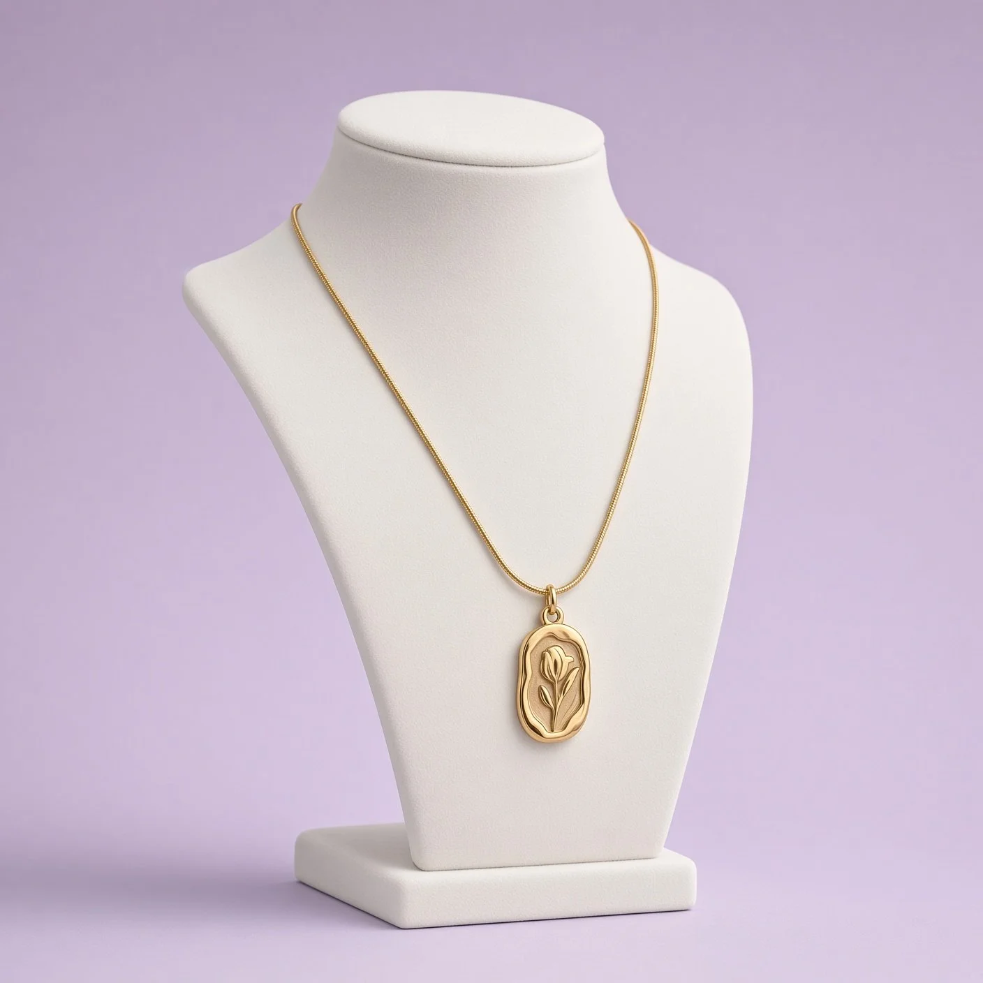 Gold-tone tulip pendant necklace on snake chain displayed on white bust, lilac background