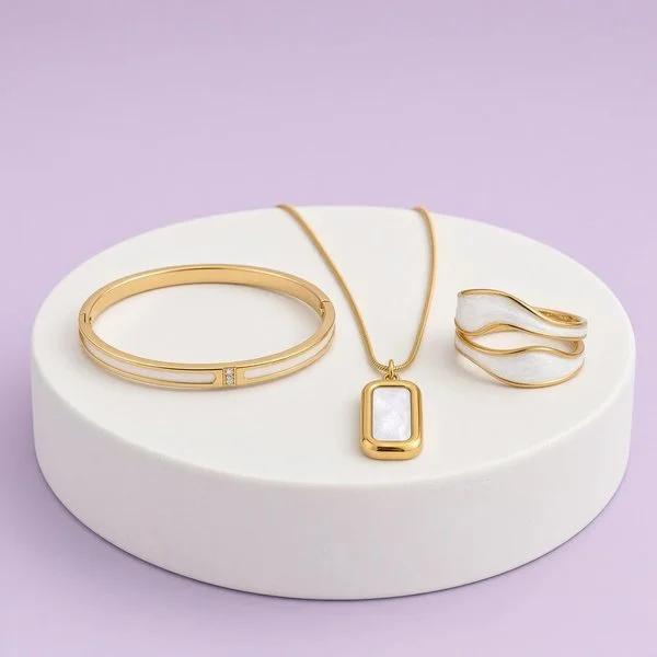 18-karat gold-plated bracelet, rectangular pendant necklace and wide ring with white inlay on a purple backdrop, Laroc Jewel Christmas gift set.
