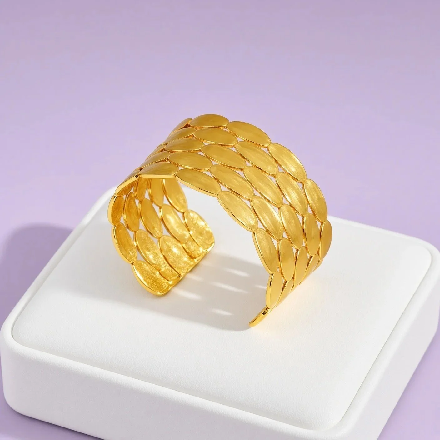 Gold-plated wide open bangle made of rows of textured leaves