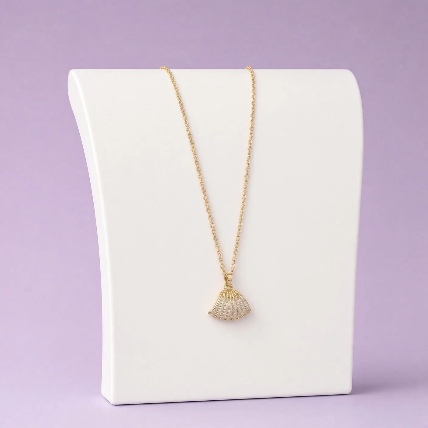 Gold dainty shell pendant necklace from Christmas Box Three on white bust, lilac background