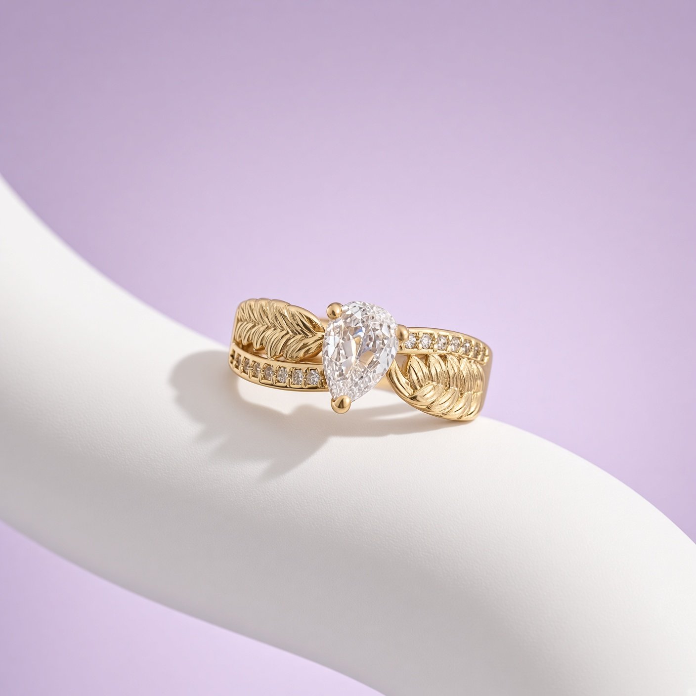 Gold leaf ring with large pear-shaped stone from Laroc Jewel on white curved stand