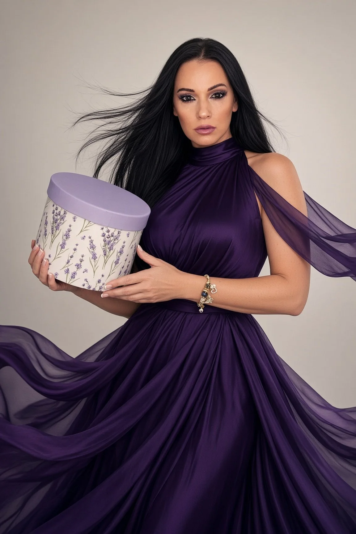 A woman in a purple dress holds a lilac floral gift box, the Autumn Mystery Box gift idea for her from Laroc Jewel, gift-wrapped 18-karat gold-plated jewelry.