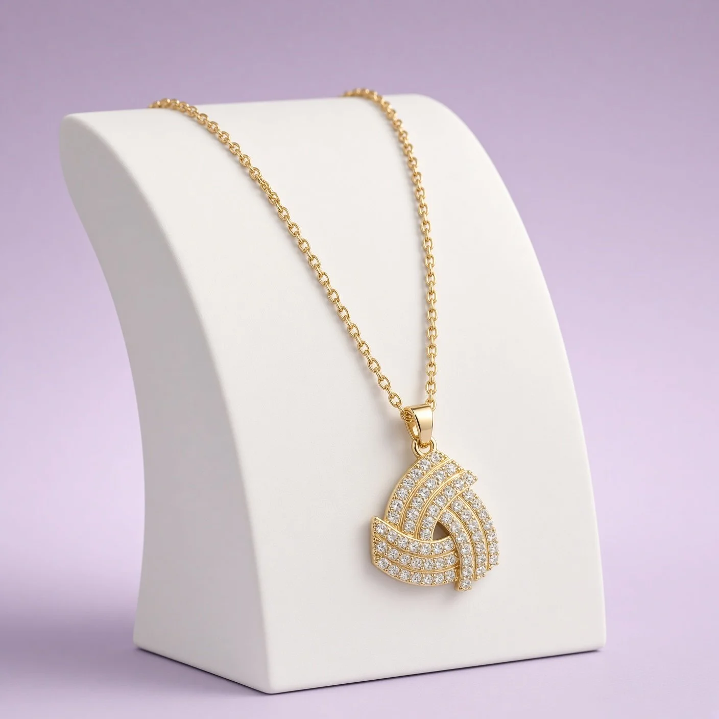 Gold sparkling knot pendant necklace from Christmas Box Two on white bust against lilac