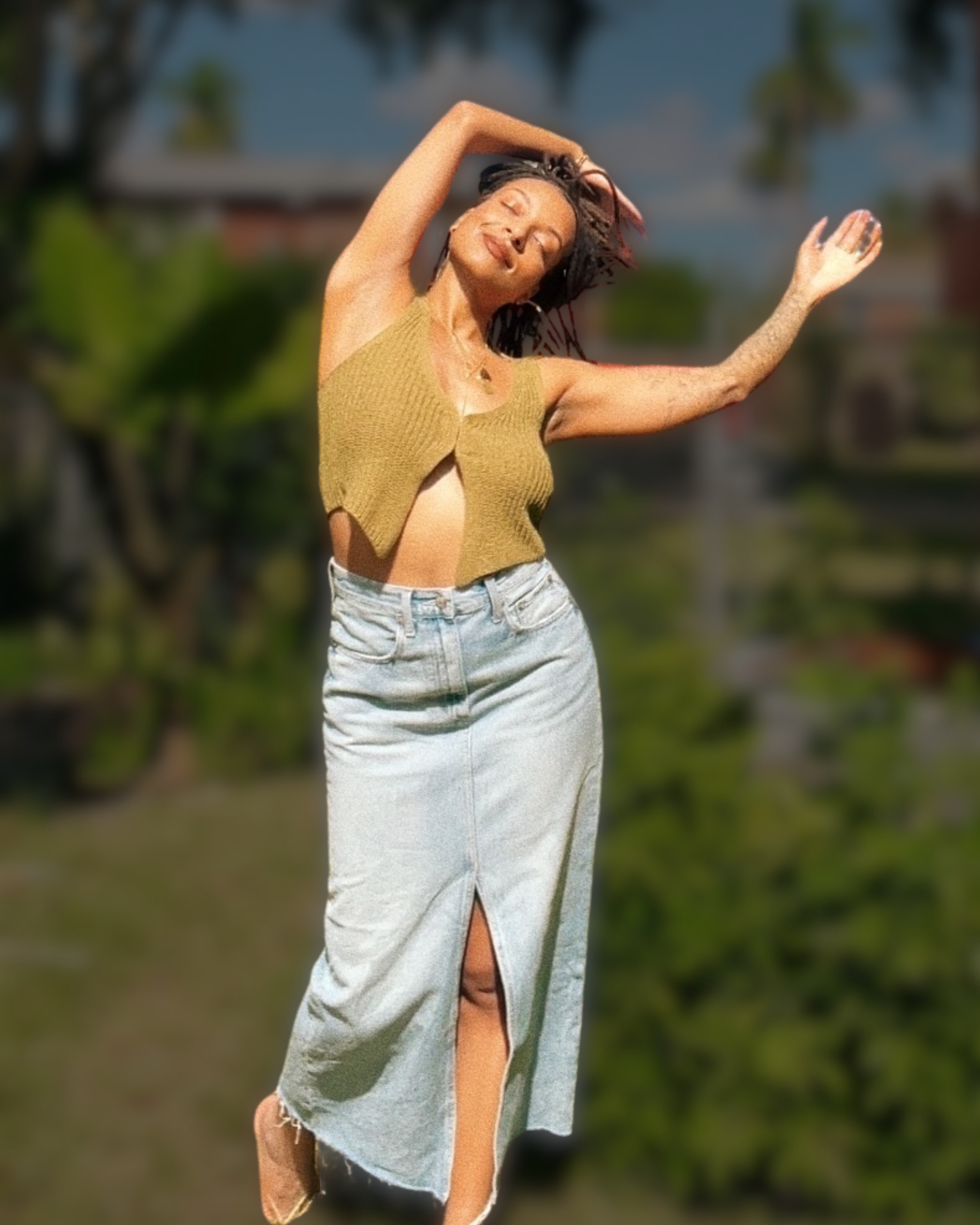 Stevie Reneé, embodiment and well-being coach, stretching outdoors in sunlight with eyes closed.