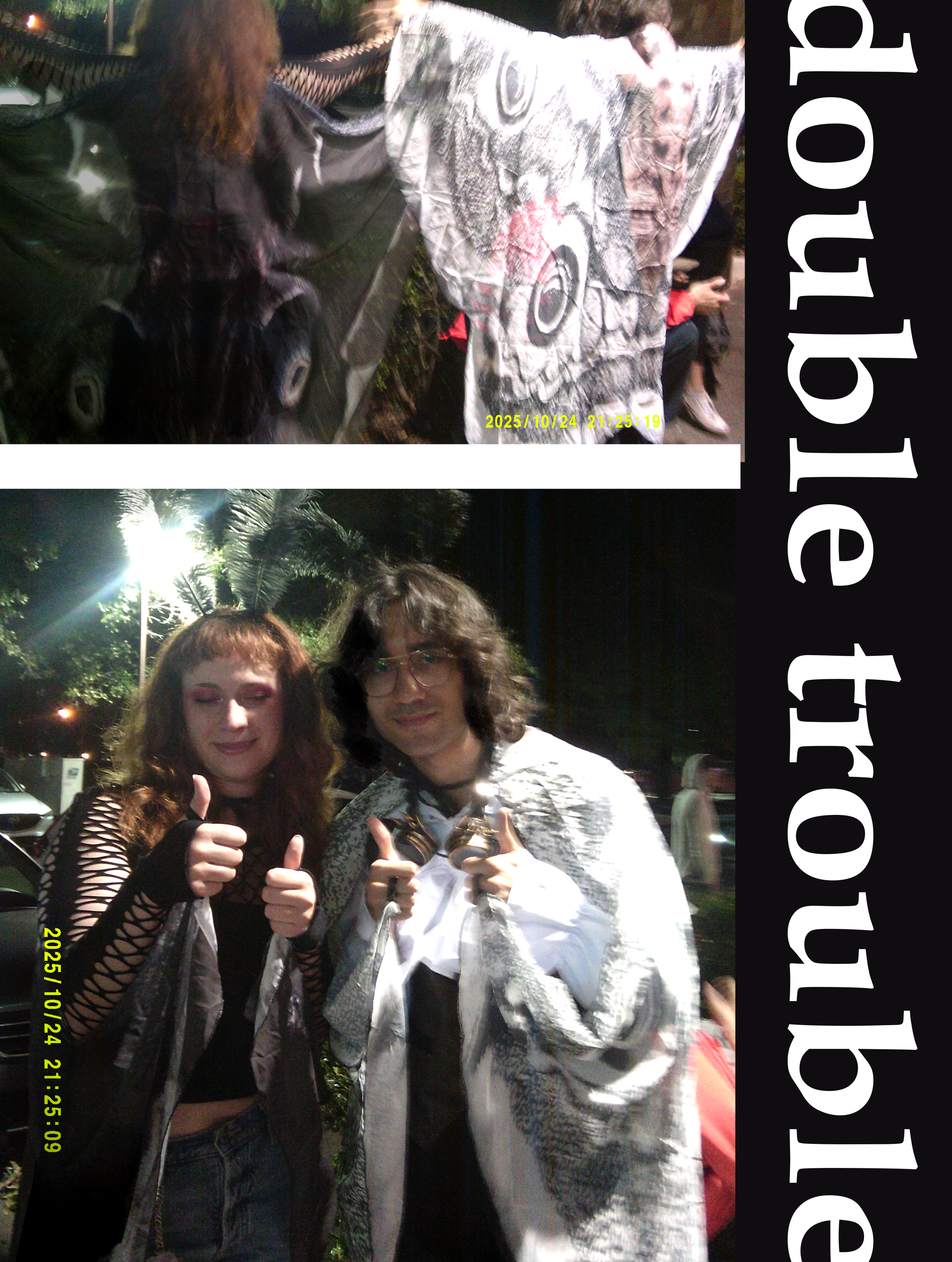 Two people dressed in gothic or rocker style posing outdoors at night, giving thumbs up. One woman with red hair and a black outfit, the other person is wearing glasses with long dark hair and a cape, with a shirt featuring a patterned design.