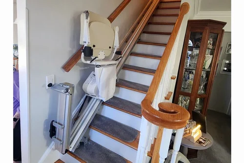 Indoor stairlift with folded rail and landing in a Westlake Village home