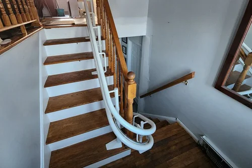 Curved stairlift with landing and railing in a Thousand Oaks home