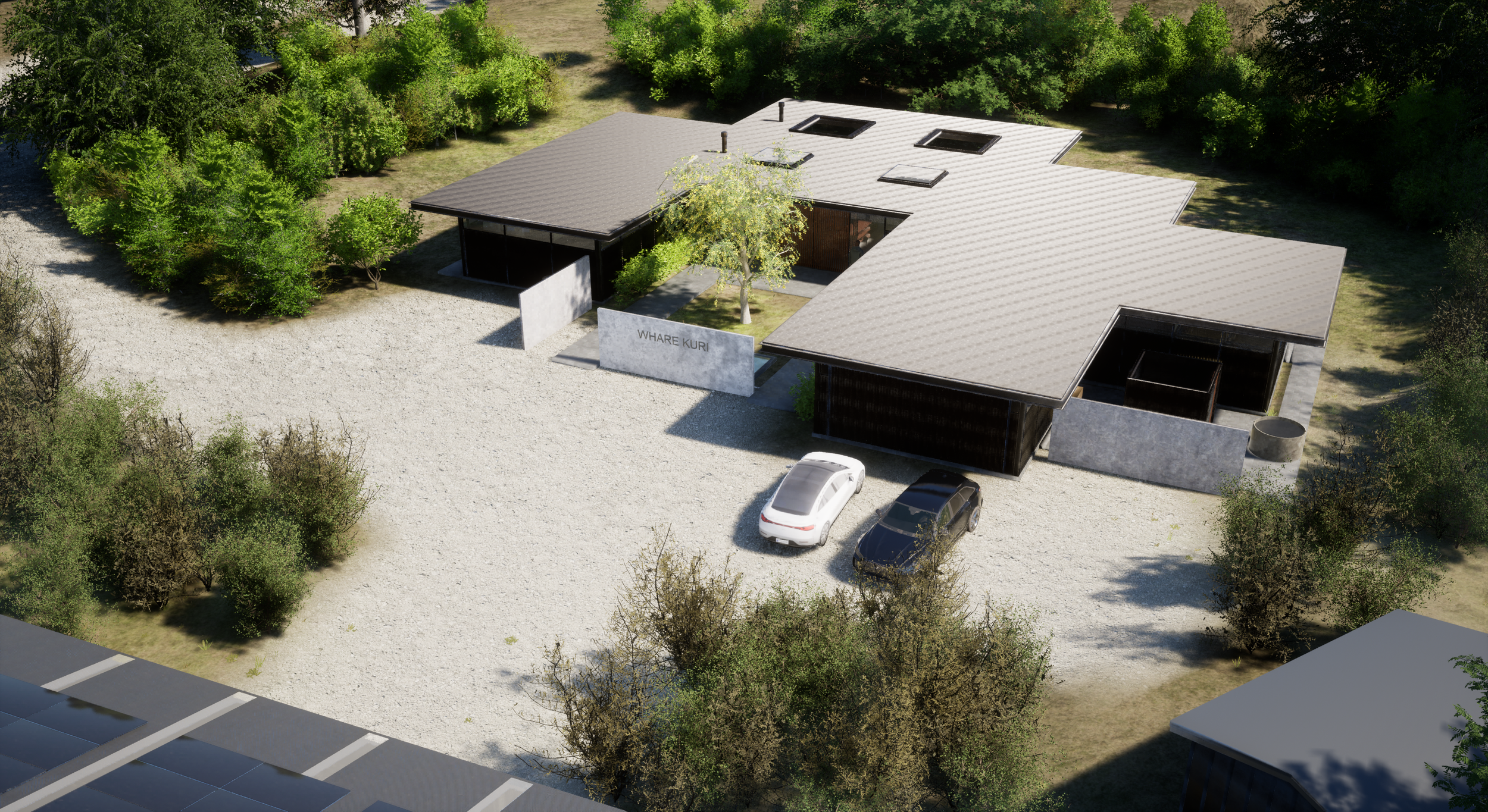 A modern one-story building with a grey roof, surrounded by greenery, a gravel driveway, and two parked cars.