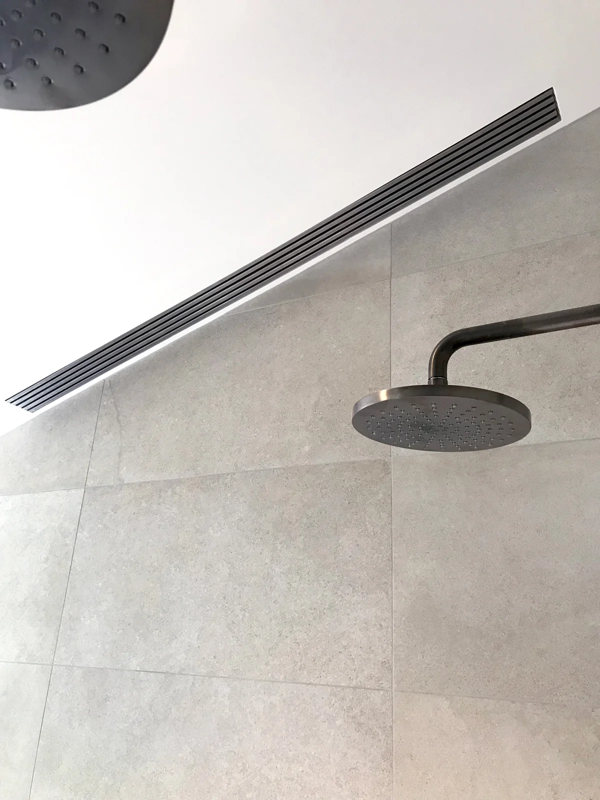 Ceiling showerhead in a modern tiled bathroom