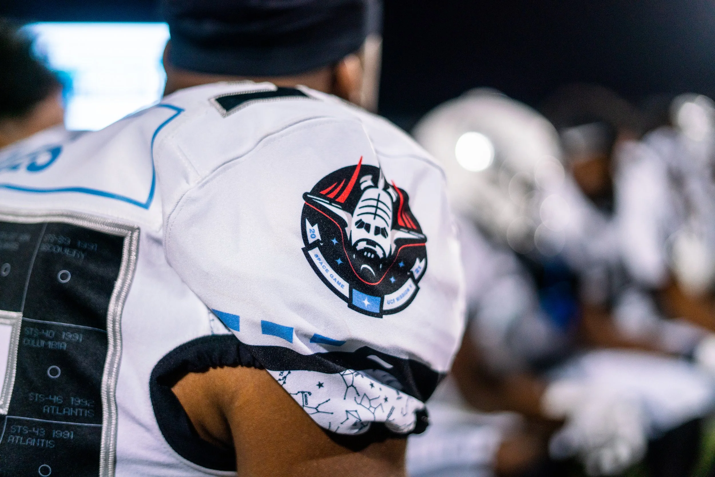 Close-up of a football player's uniform with a NASA-themed space exploration patch on the shoulder during a game.