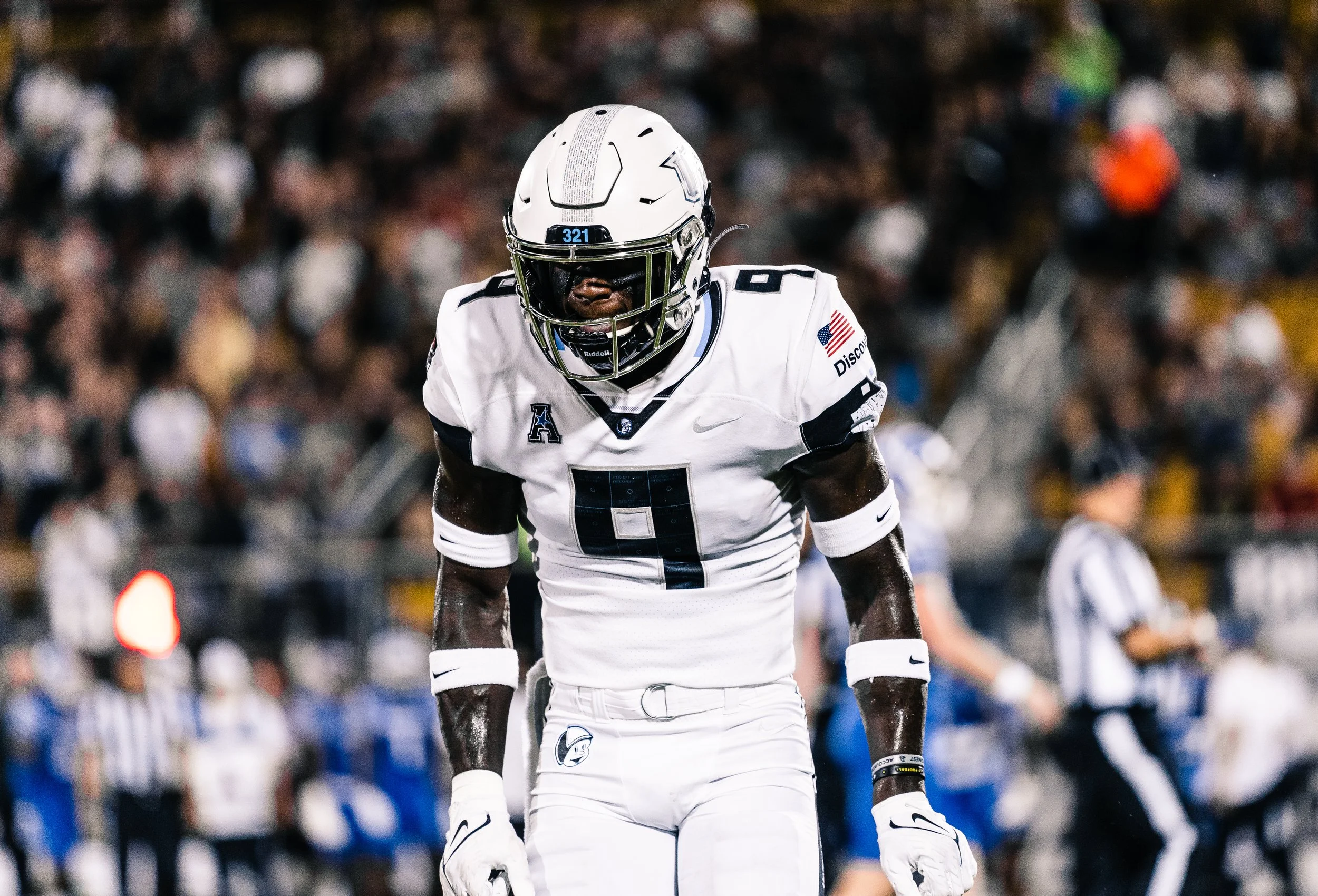 An American football player wearing a white jersey with the number 9, a white helmet, and black face mask, standing on the field during a game.
