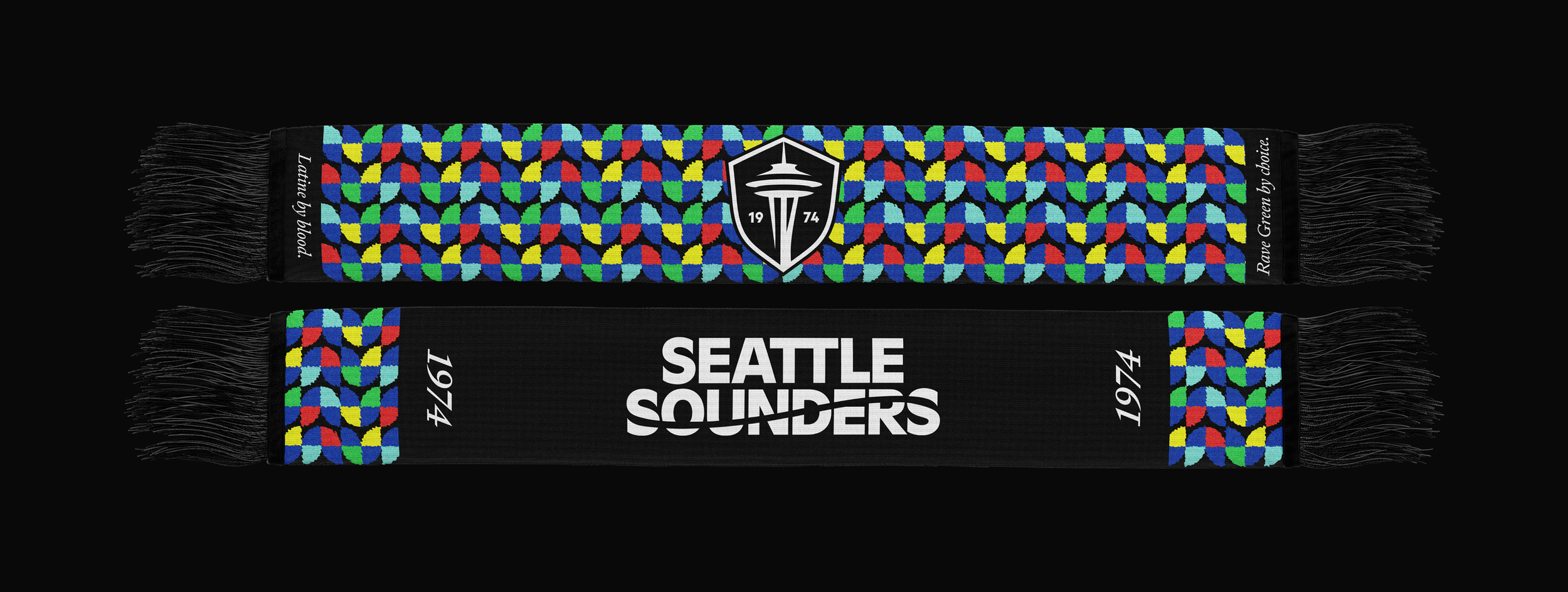 Two Seattle Sounders scarves with black fringe on a black background. One has a colorful geometric pattern and a Seattle Sounders logo, the other has white text reading "SEATTLE SOUNDER$" and the years "1974" and "1946".