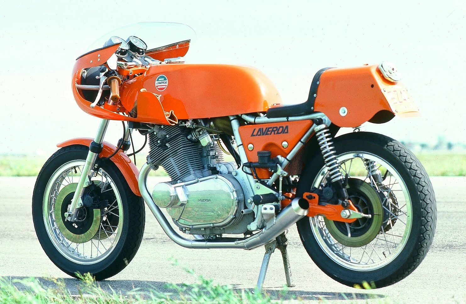 An orange Laverdas racing motorcycle parked on a paved surface with a grassy background.