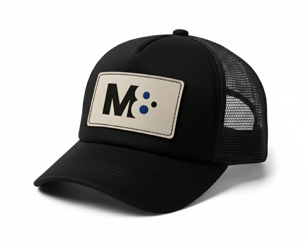 Structured black trucker hat featuring a woven front patch and mesh back. Designed for brands that want a tactile, distinctive look without sacrificing everyday wearability.