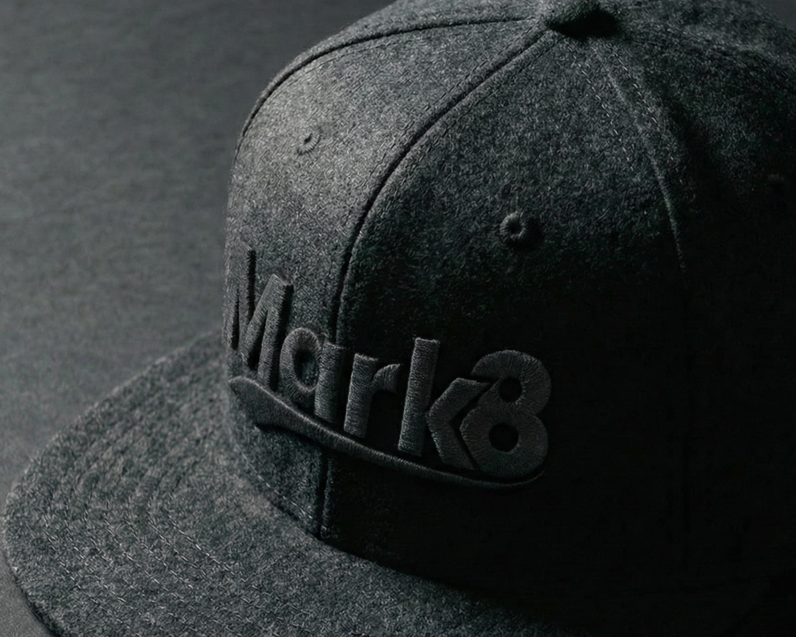 Black flat brim hat on a dark background