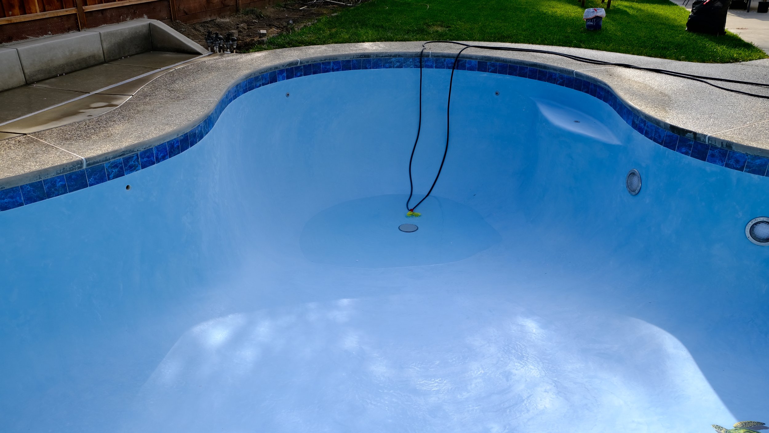Pool remodel with blue plaster finish, steps, and mosaic turtle tile detail by NorCal Pools Inc in Northern California