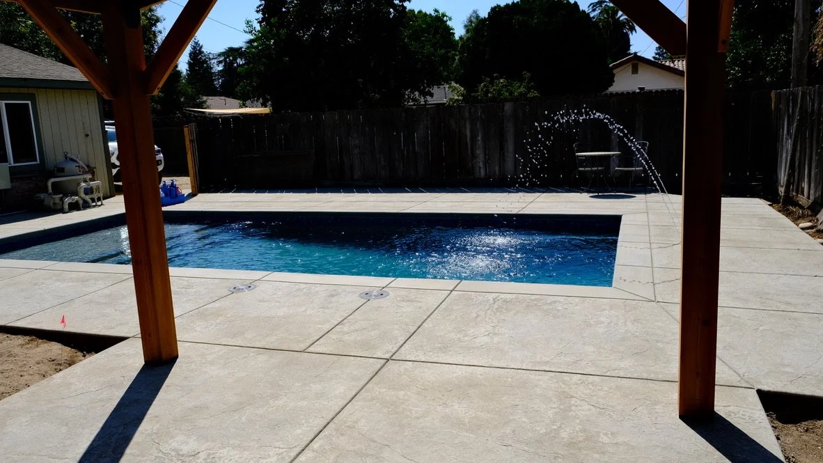 Custom pool with deck jets and pergola by NorCal Pools Inc in Northern California