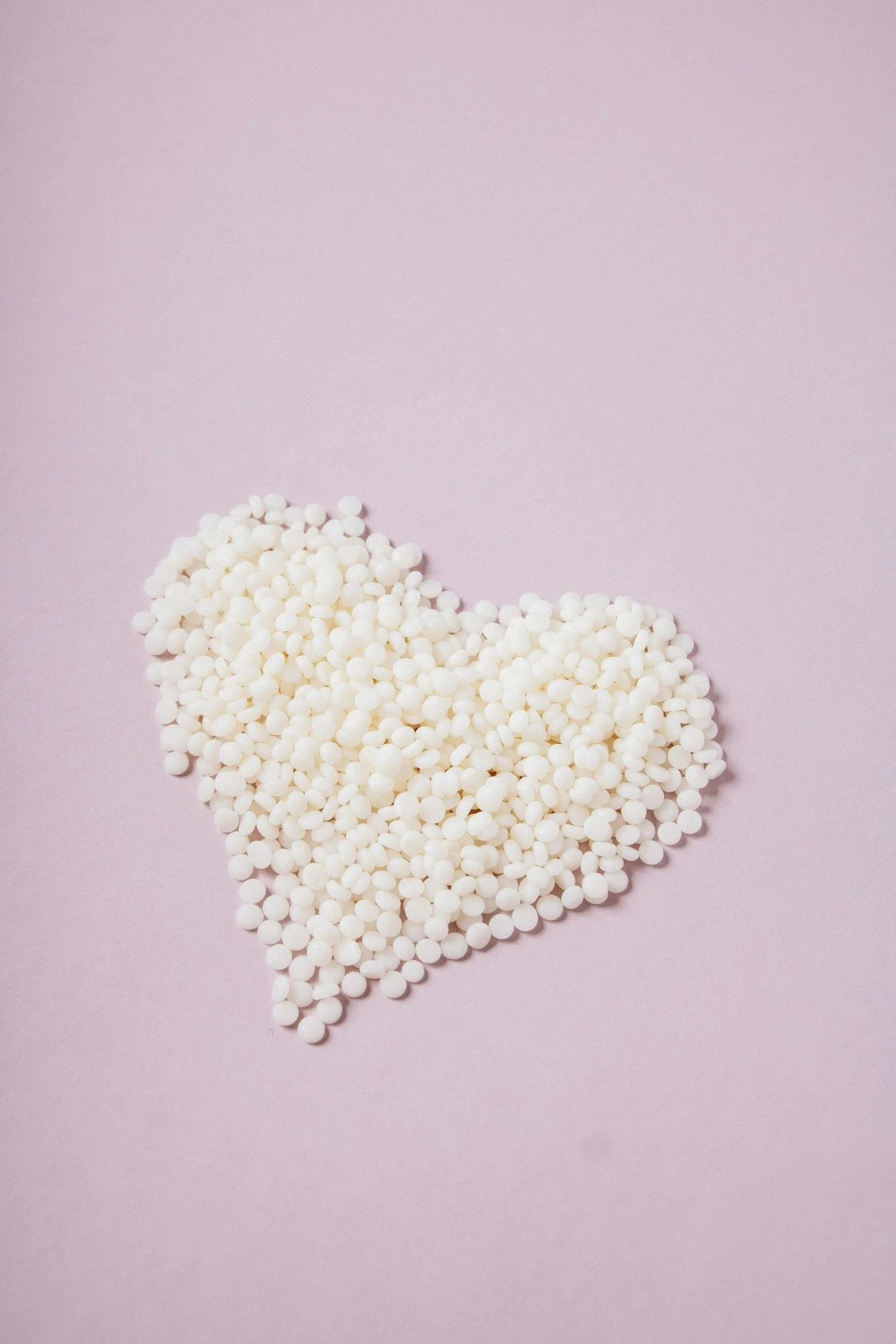 Many small white round objects arranged in the shape of the state of Texas on a pink background.