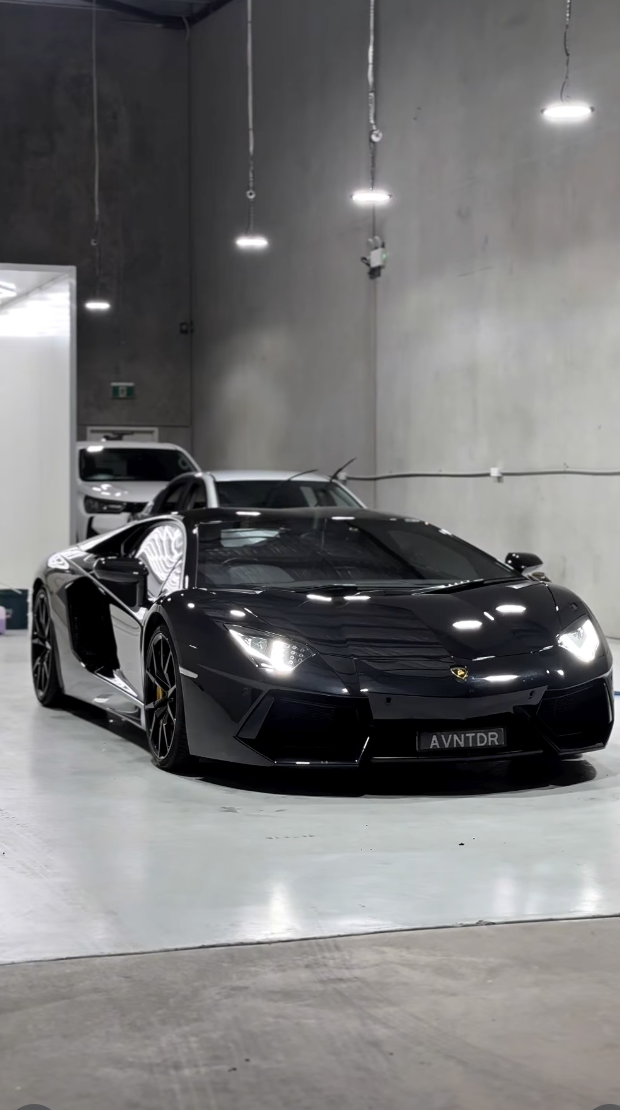 High-level paint correction and detailing on a black sports car, removing swirl marks and restoring mirror-like clarity at Autobiography Detailing.