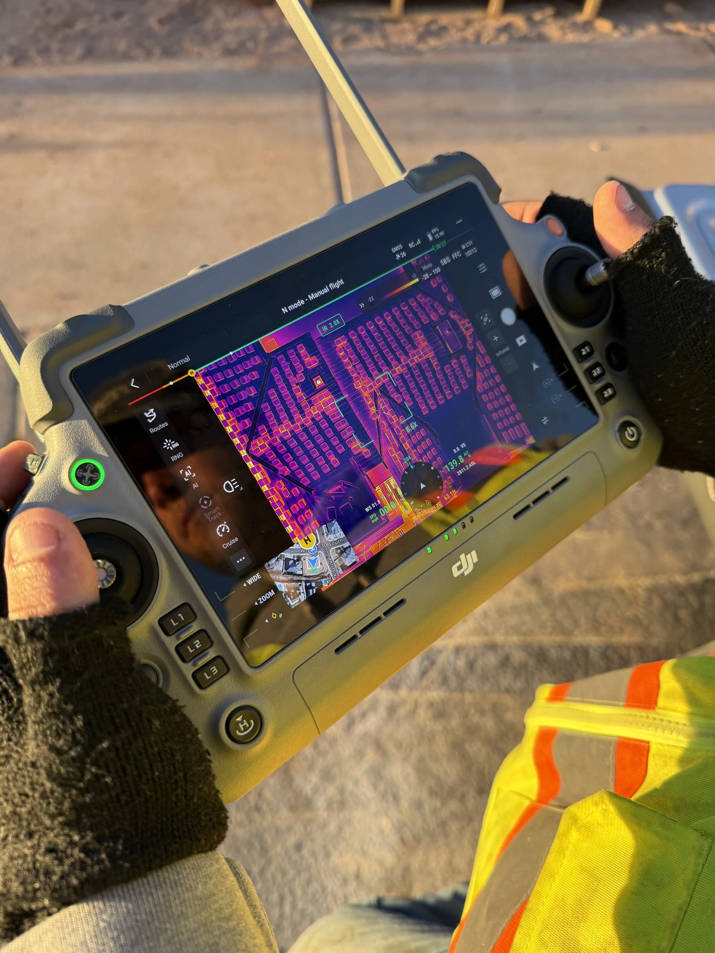 Infrared image of a house roof showing solar panels and ventilation areas.