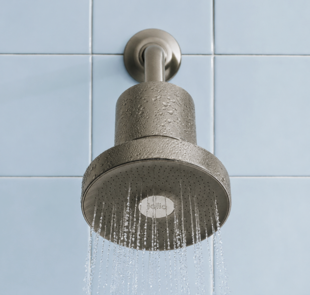 Showerhead releasing running water against a light blue tiled wall.