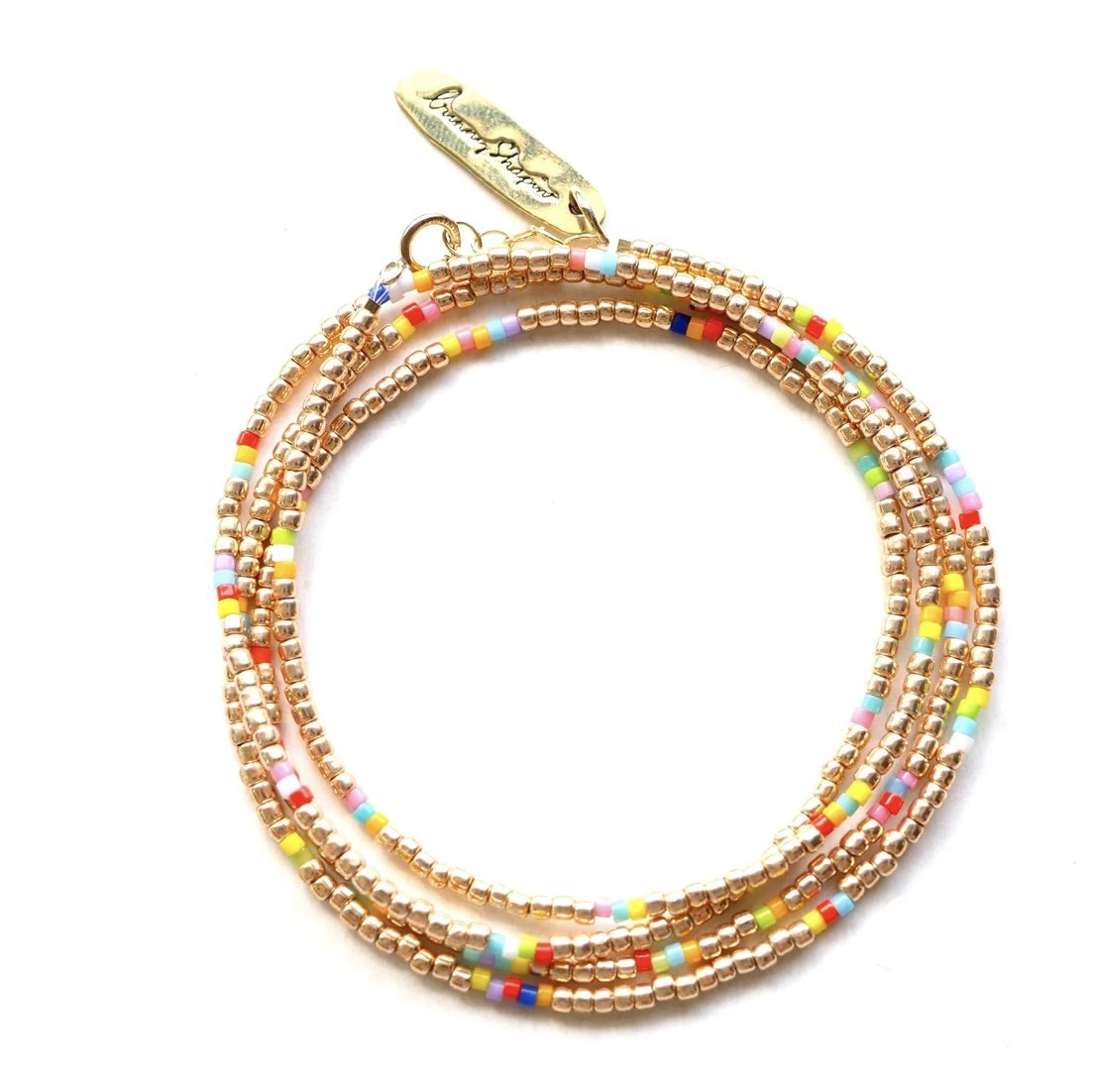 Colorful beaded bracelet with gold accents and a gold charm label.