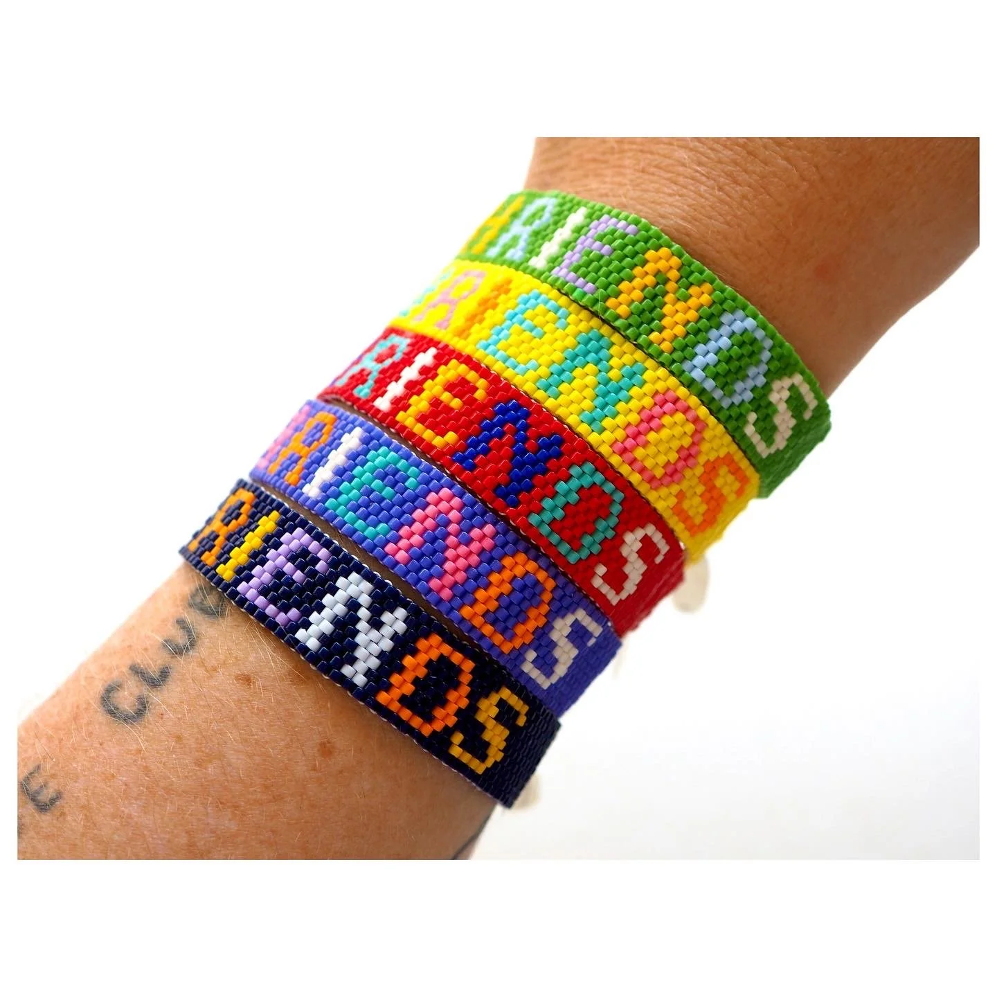 Multiple colorful beaded Bunny Shapiro bracelets with the word PHRIENDS for a collaboration with world famous musician and fashion designer Pharrell Williams.  This collaboration was created also with Sarah Andelman from Colette. 