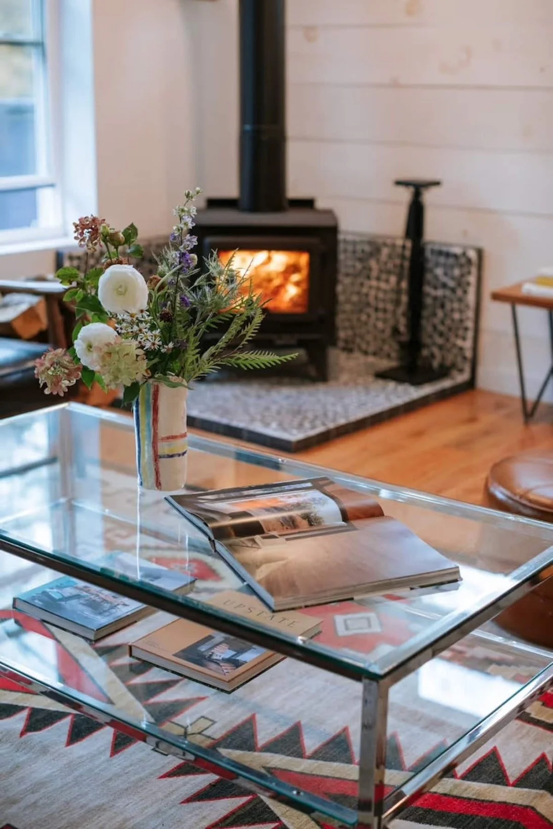 Living room with a wood stove where friends and family can gather to read, play games and relax at The Black Bear Cottage, just a few hours away from Brooklyn and New York city- Perfect for a weekend escape