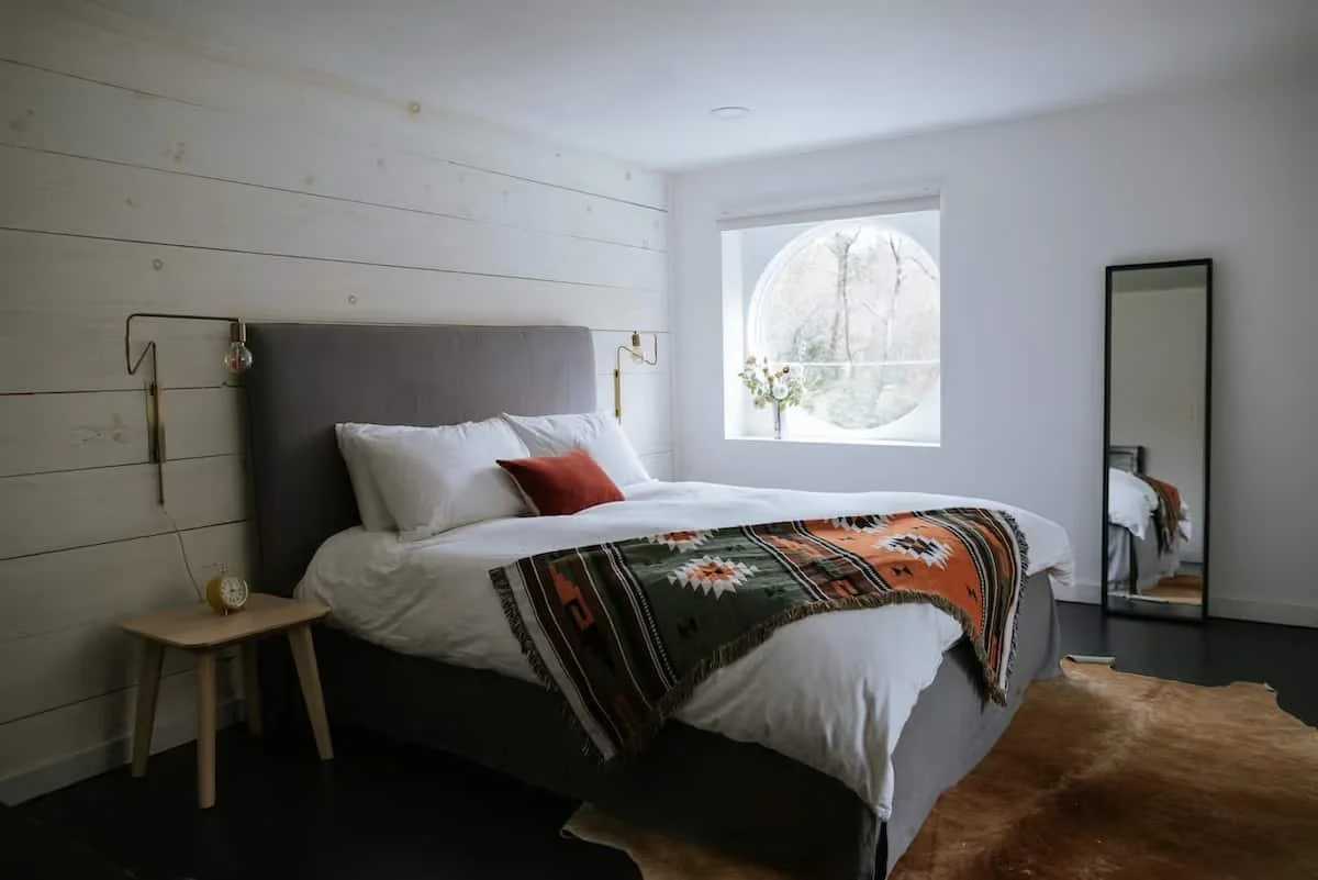 Light-filled primary suite at Black Bear Cottage, Catskills vacation rental with spacious bedrooms-Design deck allows for working remotely
